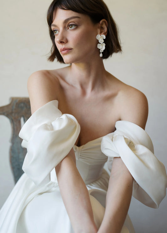 Pair of white floral earrings on model